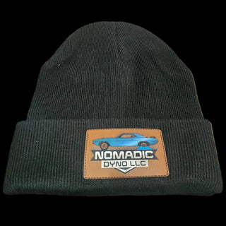 Black beanie with a logo patch on a textured surface Nomadic Dyno