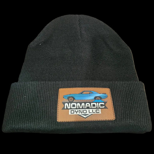Black beanie with a logo patch on a textured surface Nomadic Dyno